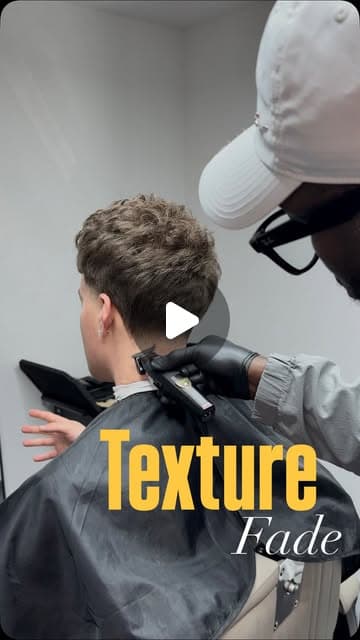 Abdoulaye shaping a textured fade on the back of a client's head with clippers